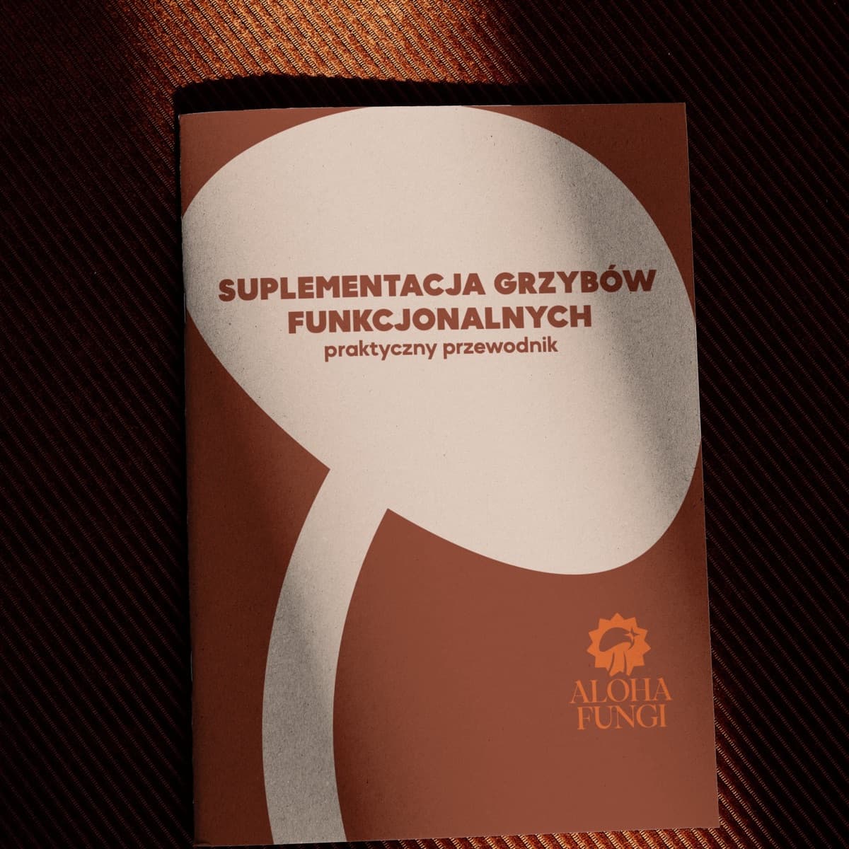 Brązowa okładka ebooka Suplementacja grzybów funkcjonalnych z logo Aloha Fungi, w kształcie dymka rozmowy.